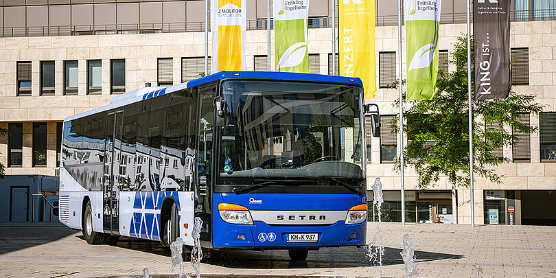 Ein weiß-blauer Bus steht auf der Straße