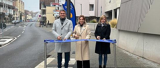 Auf dem Foto sind drei Personen zu sehen, die das RNN Band durchschneiden